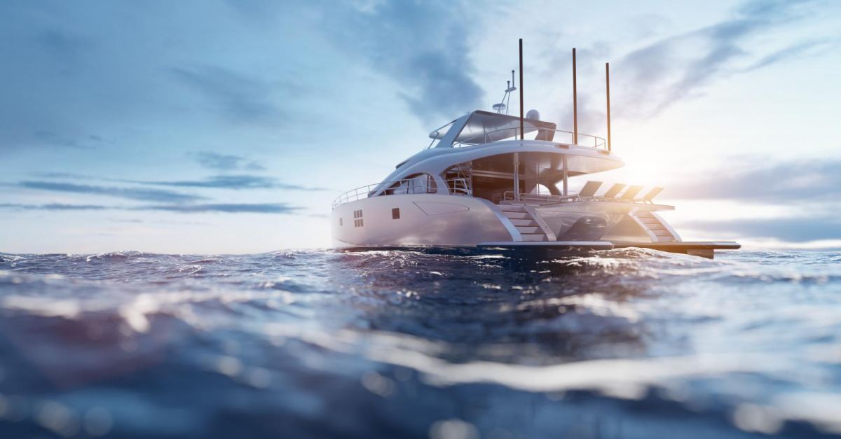 A motor yacht under way at sunset, seen low from the waterline